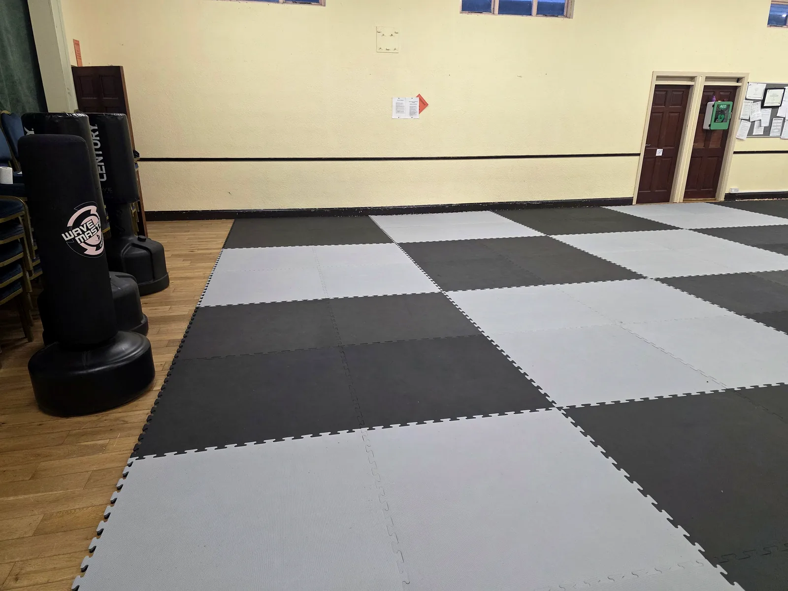 Leinster TaeKwon Do training hall in Riverchapel with grey and black mats laid out and freestanding punch bags to the side